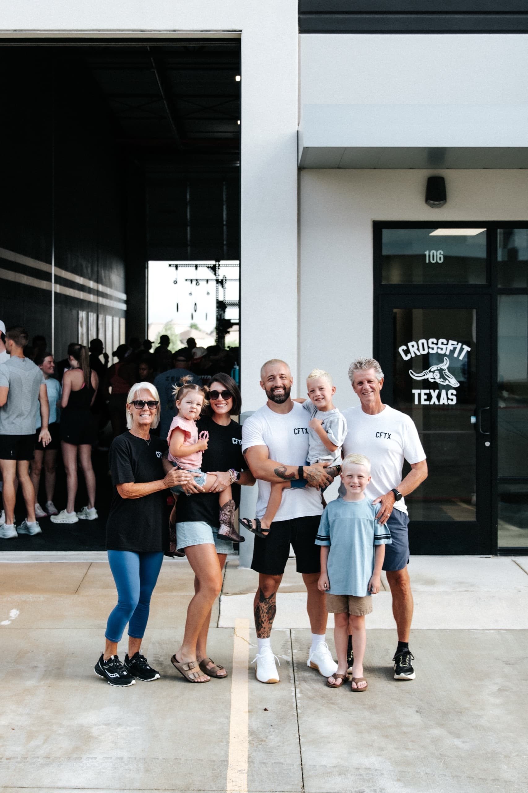 A family standing outside the CrossFit Texas entrance at Suite 106